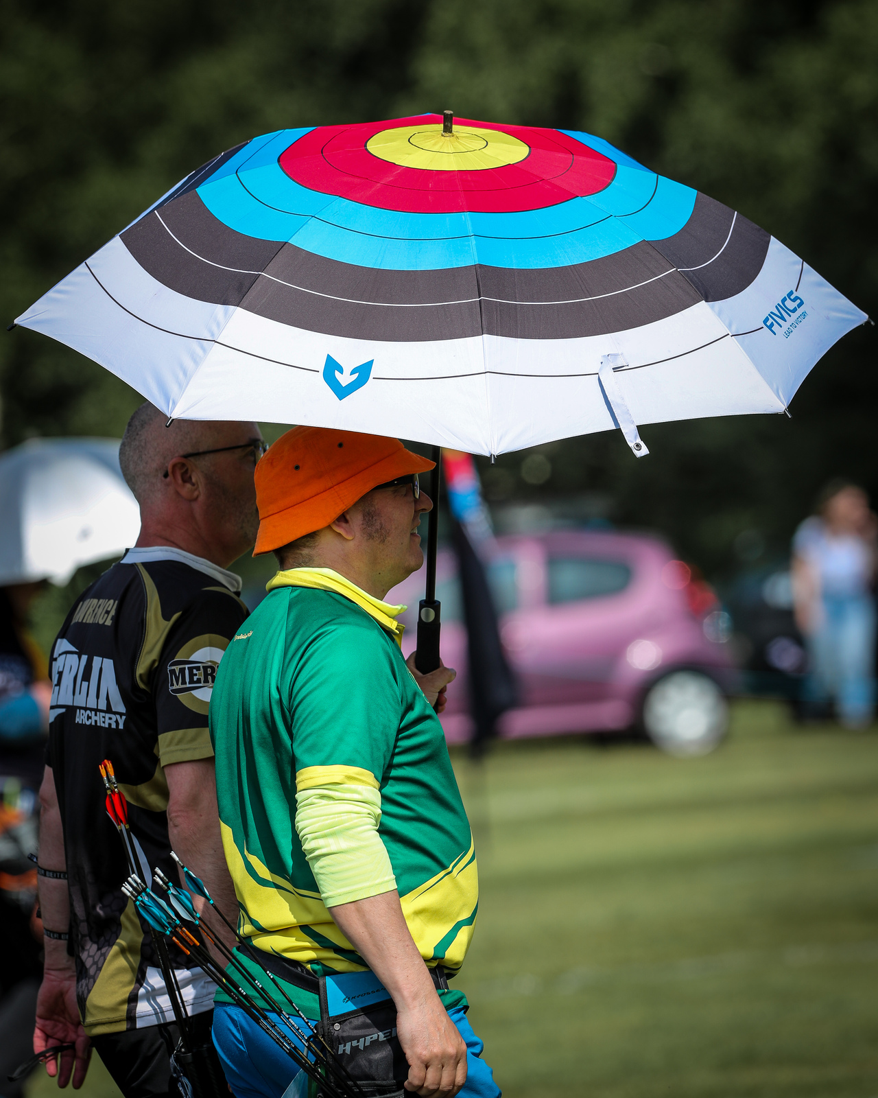 Archers standing under an umbrella